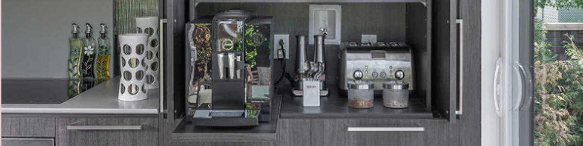 Station café intégrée dans des armoires de cuisine sombre, offrant un espace fonctionnel et bien organisé pour faciliter le quotidien familial.